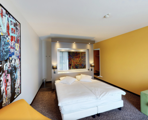 La photo montre l'intérieur d'une chambre d'hôtel moderne et artistiquement décorée d'un hôtel en Suisse.